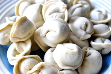 Fototapeta na wymiar White dumplings with meat on a blue plate