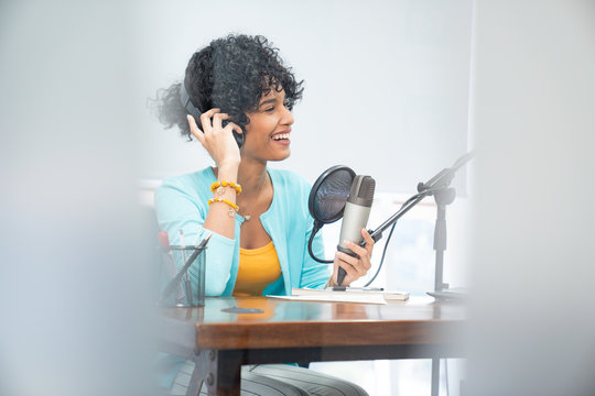 Good looking young black female making an online podcast recording