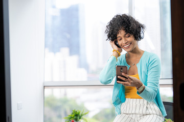 Young Black Woman Listening To Music Using Bluetooth Headphones Mobile