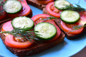 Diet sandwiches made of black flour with tomatoes and cucumber