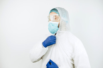 Fototapeta premium portrait of tired doctor after shift in the hospital. The doctor in protective clothing - glasses, mask, gloves on white background. The doctor treating patients with coronavirus. Covid-2019