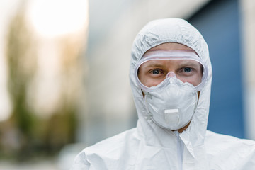 Close-up of a man doctor in a protective mask and PPE suit to protect against a coronavirus outbreak in a global pandemic. The concept of quarantine Covid-19.