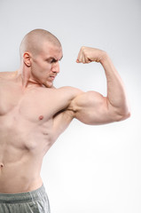 Obraz premium Sexy athlete posing on a white background Topless. Fitness