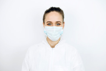 portrait of tired doctor after shift in the hospital. The doctor in protective clothing - glasses, mask, gloves on white background. The doctor treating patients with coronavirus. Covid-2019