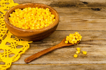 Sweet ripe canned corn in wooden bowl.