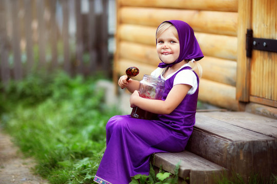 a girl in a Masha costume from a Russian cartoon eats jam