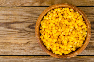 Sweet ripe canned corn in wooden bowl.
