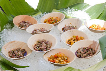 Ceviche os different types in wooden plates on a ice surface.
