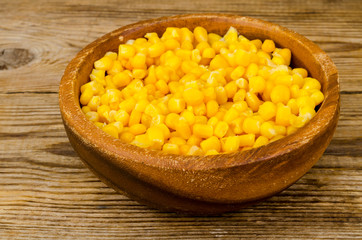 Sweet ripe canned corn in wooden bowl.