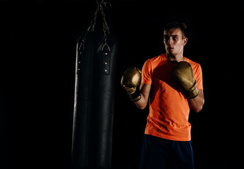 Hispanic MMA Fighter practicing some kicks with a punching bag