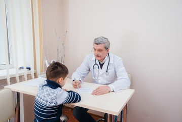 A young boy is listened to and treated by an experienced doctor in a modern clinic. A virus, and an epidemic