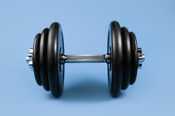 Obraz na płótnie Canvas Professional dumbbell and weight plates over blue background. Gym equipment. Fitness concept.