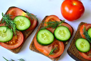 Several diet sandwiches with cucumber and tomato from black bread