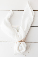 egg wrapped in a towel, handkerchief, on the wooden floor, light background, white boards, Easter, decorated egg.