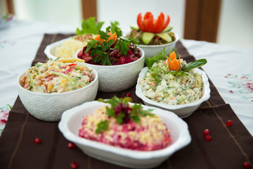 Diet salad with beets . Capital salad . Potato salad . coleslaw salad . set with different salads . Salad ham, orange pepper, mushrooms, pickles, white sauce, on a white bowl.