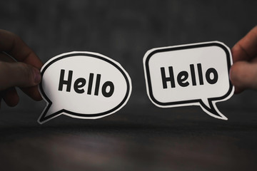 hands hold a paper cloud with the word hello