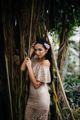 Obraz premium A young beautiful brunette posing among dense thickets of jungle and rainforest. Spa