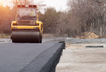 The vibratory roller levels the asphalt pavement