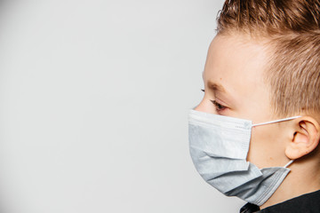 Face of a guy in a medical mask sideways on a white background