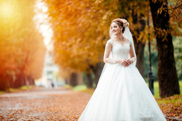 Beautiful bride in fashion wedding dress on natural background.The stunning young bride is incredibly happy. Wedding day