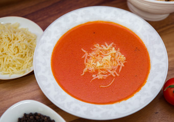 Red lentil soup . Spaghetti white plate . Dry bread and pepper . Red tomatoes . Tomato Soup wooden tray .