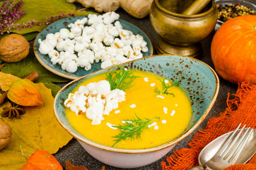 Seasonal pumpkin cream soup with popcorn. Photo