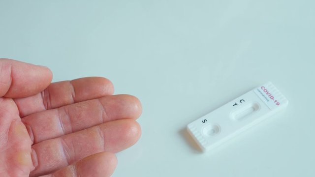 doctor or nurse in protective glove disinfect patient with alcohol and pricks a finger for blood samlping to rapid test for viral disease COVID-19