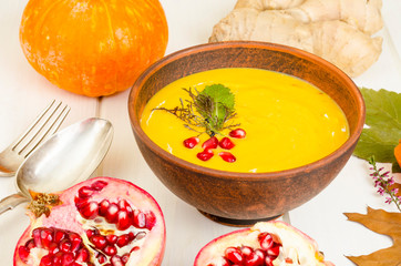 Spicy pumpkin carrot soup cream with pomegranate.