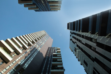 Fototapeta na wymiar View of three multi-story futuristic buildings forming a circle with balconies against a blue sky. 01.20 Milan.