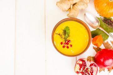 Spicy pumpkin carrot soup cream with pomegranate.