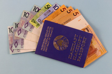 Belarusian passport and new banknotes in the Republic of Belarus with a face value of one hundred fifty five rubles. Separate on a blue background.