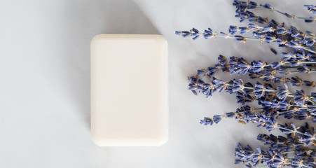 Obraz na płótnie Canvas Flat lay composition with lavender flower and soap on white marble background. Concept natural hand made product, minimal, copy space, top view