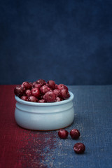 Cherry in a blue bowl on a blue background