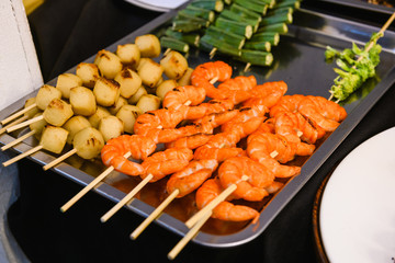 Grilled seafood on wooden skewers close up