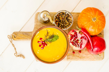 Spicy pumpkin carrot soup cream with pomegranate.