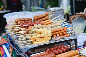 Meat pieces and sausages on wooden skewers