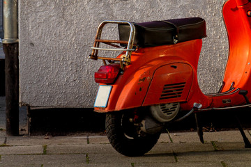 orange scooter on wall background