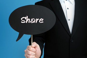 Share. Geschäftsmann im Anzug hält Sprechblase in die Kamera. Der Begriff Share steht im Schild....