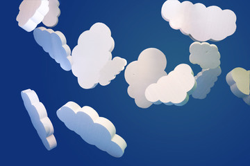 Clouds cut out of Styrofoam scenery on a blue background. White, inverted toy clouds.