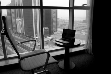 a chic workplace in front of the window with a designer chair and a MacBook