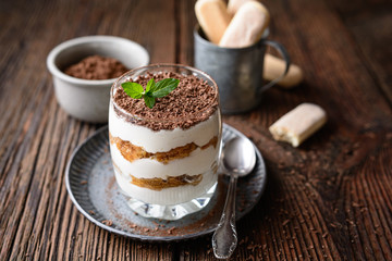 Classic Italian coffee no bake dessert, delicious easy Tiramisu in a jar, sprinkled with cocoa powder and chocolate shavings