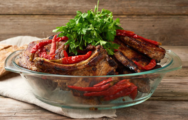 grilled pork steaks on the bone lie in a transparent glass plate