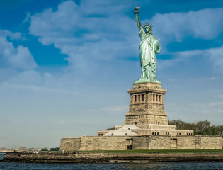 Fototapeta premium The Statue of Liberty in New York City. Statue of Liberty with blue sky over hudson river on island. Landmarks of lower manhattan New York city.