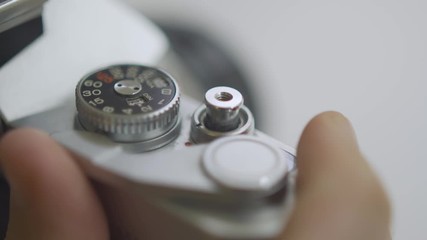 Cocking shutter on old 35mm film camera and then pressing shutter release button