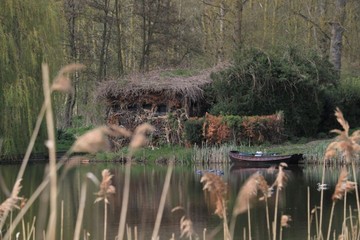 vieille barque de pêcheur et hutte de chasseur au bord d'un lac