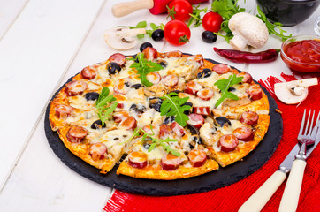 Tasty pizza with salami, mozzarella, mushrooms and olives on wooden background.