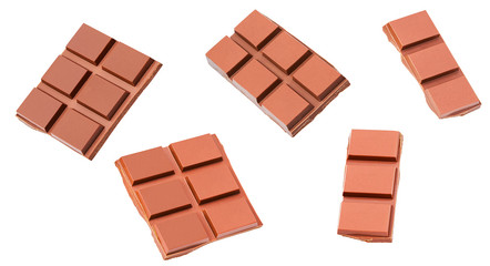 Milk chocolate pieces isolated on white background, close-up.