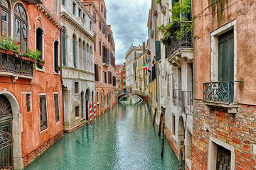 Fototapeta na wymiar Canal with boats in Venice (Italy) on a cloudy day in late autumn