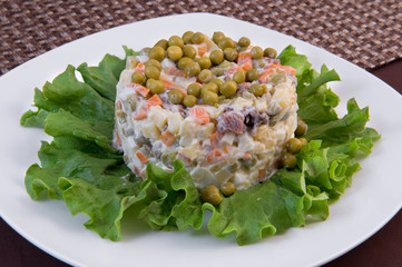 Traditional Olivier salad of potatoes, canned green peas, boiled carrots, pieces of meat, pickled...