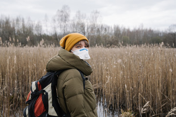 Portrait of woman wearing face mask and disposable gloves outdoors